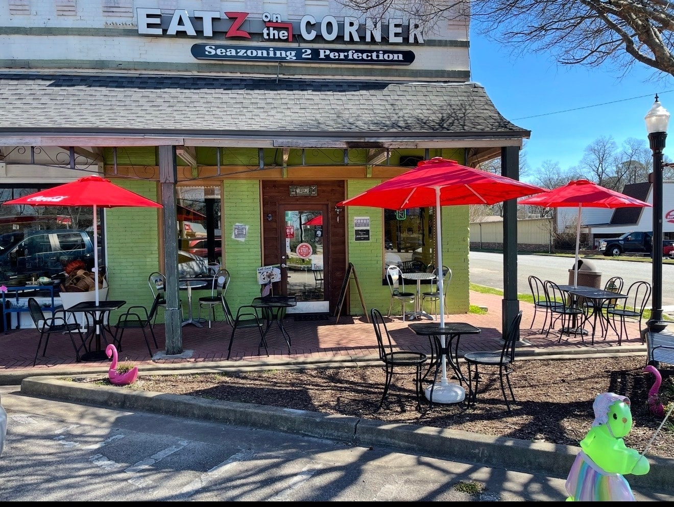 Eatz on the Corner storefront with red umbrellas and outdoor patio seating