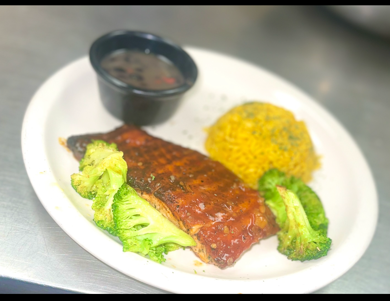 Eatz Grill glazed salmon with broccoli, yellow rice, and black beans